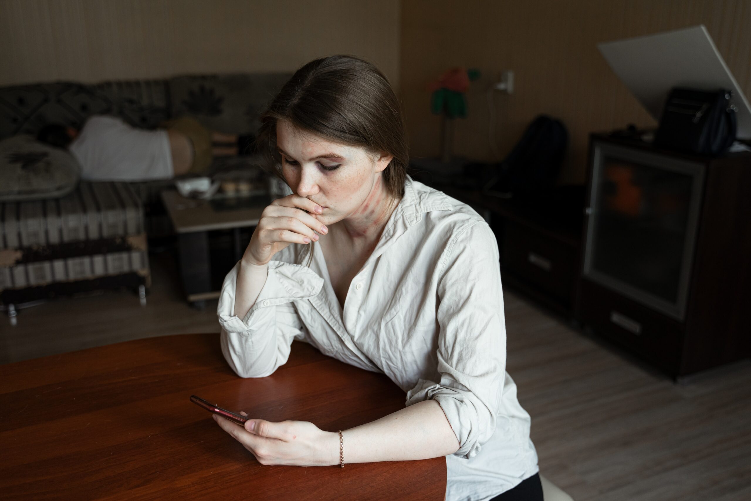 A woman looking at her phone at a kitchen table